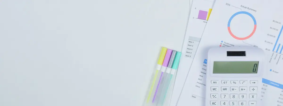 A calculator, budget documents and pens on a desk