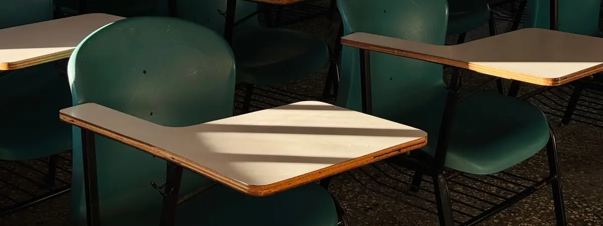 An empty exam room with rows of desks and chairs