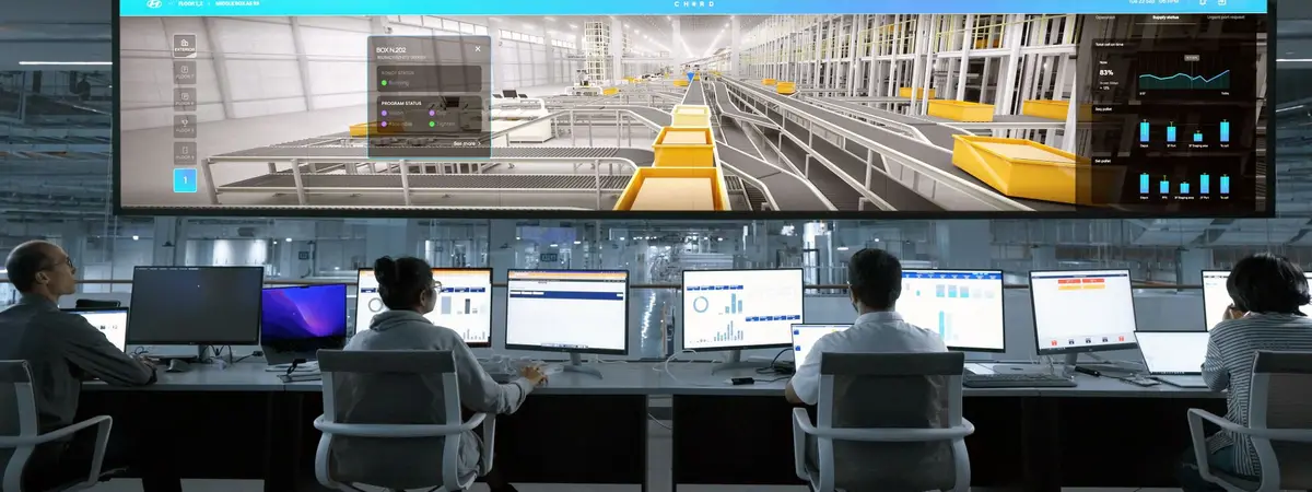Operators at workstations watching large system displays in a control room