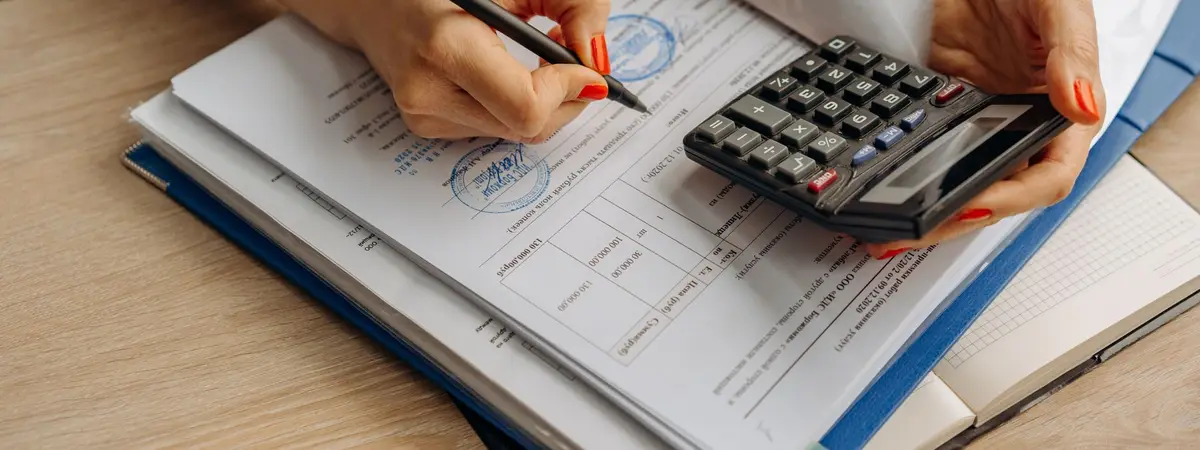 An accountant using a calculator while reviewing paperwork