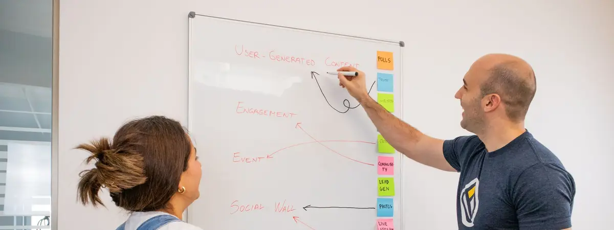 Two colleagues mapping a marketing plan on a whiteboard