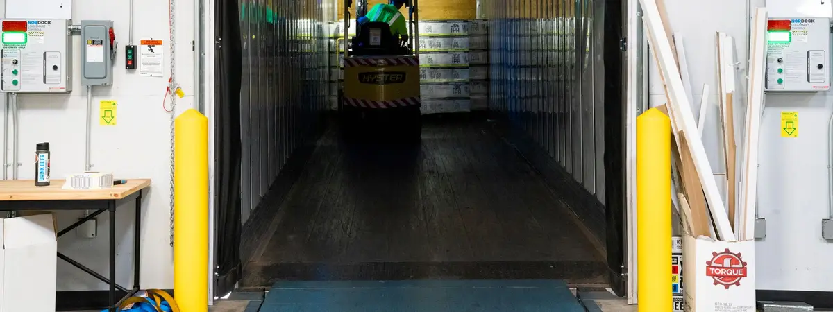 A forklift unloading goods at a warehouse loading dock