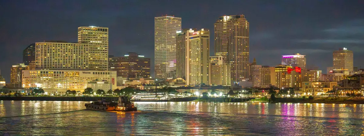 The New Orleans, Louisiana skyline at night over the Mississippi River