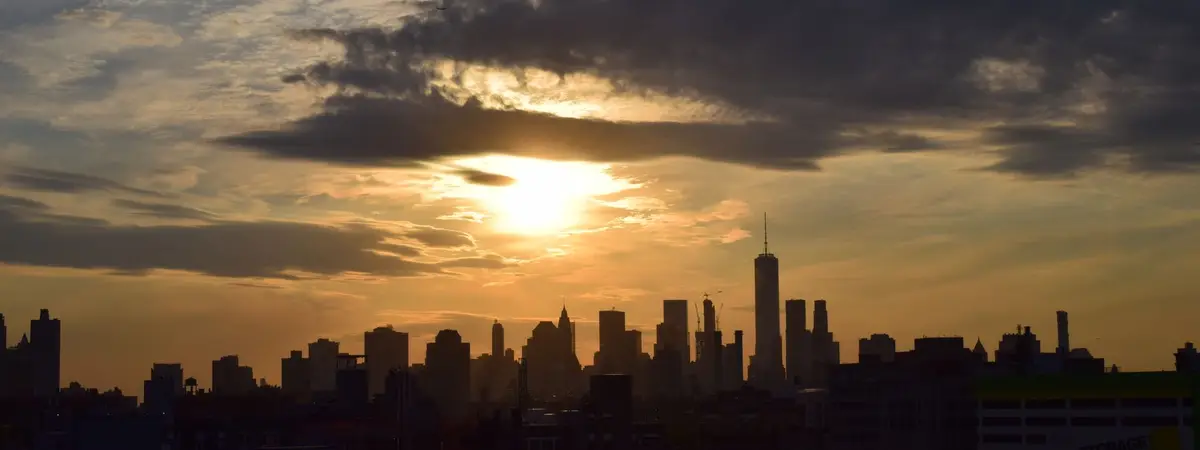 The New York City skyline in silhouette at sunset