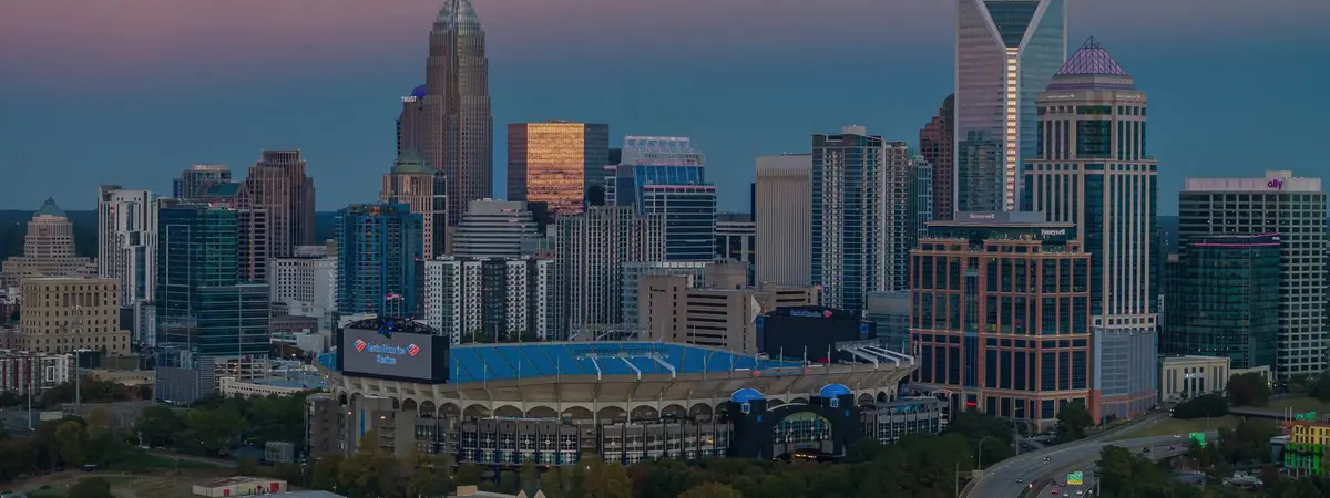 The Charlotte, North Carolina skyline at dusk beside its stadium